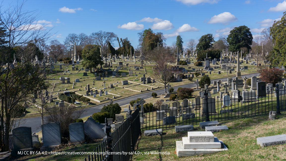 Photograph of the landscaped grounds at Hollywood Cemetery in Richmond, featuring rolling hills, mature trees, and historic monuments